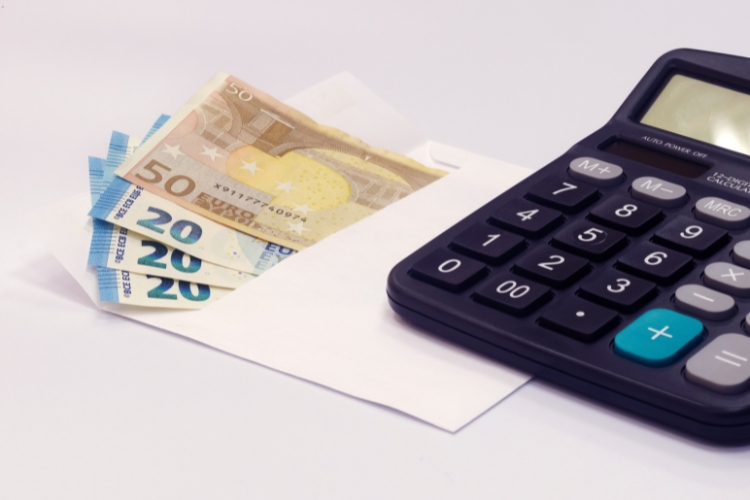 calculator, pounds money and paper placed on table