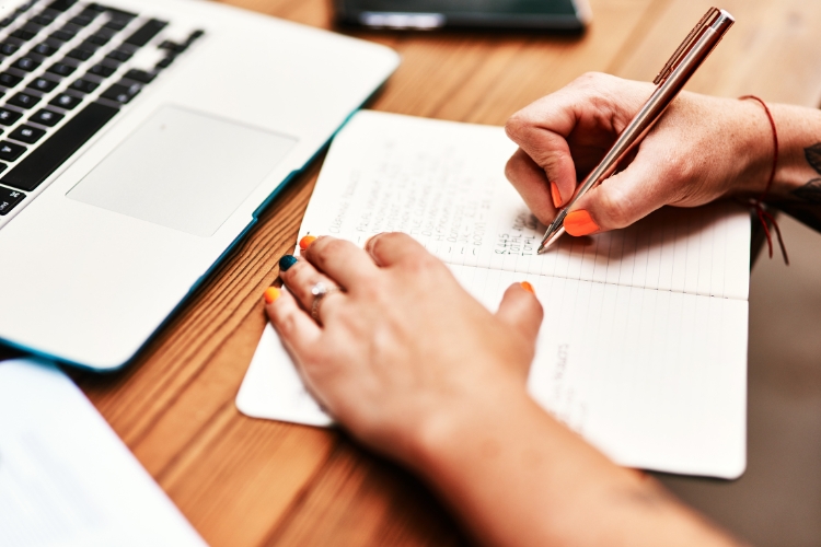 woman writing on notepad focus