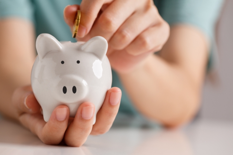 woman adding coins into money bank