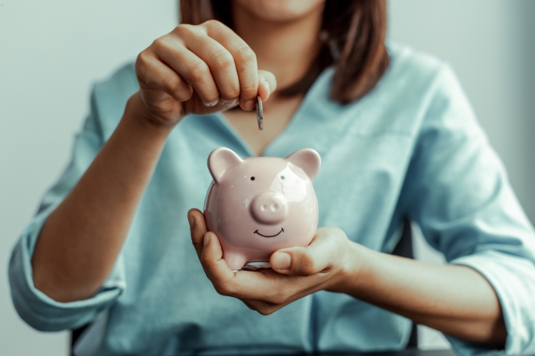 woman holding coin and money bank focus